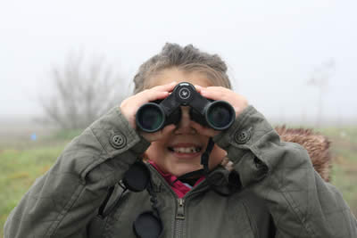 girl looking through binoculars